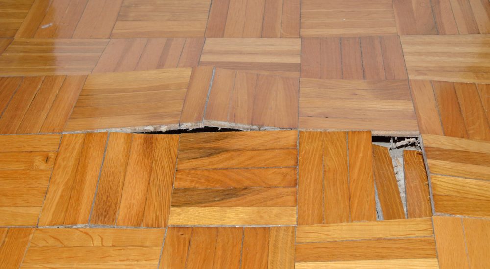 Wooden floor in apartment with floor damaged by destructive elements such as wet, moisture, water.