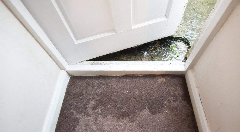 water leaking through a doorway, damaging the hall